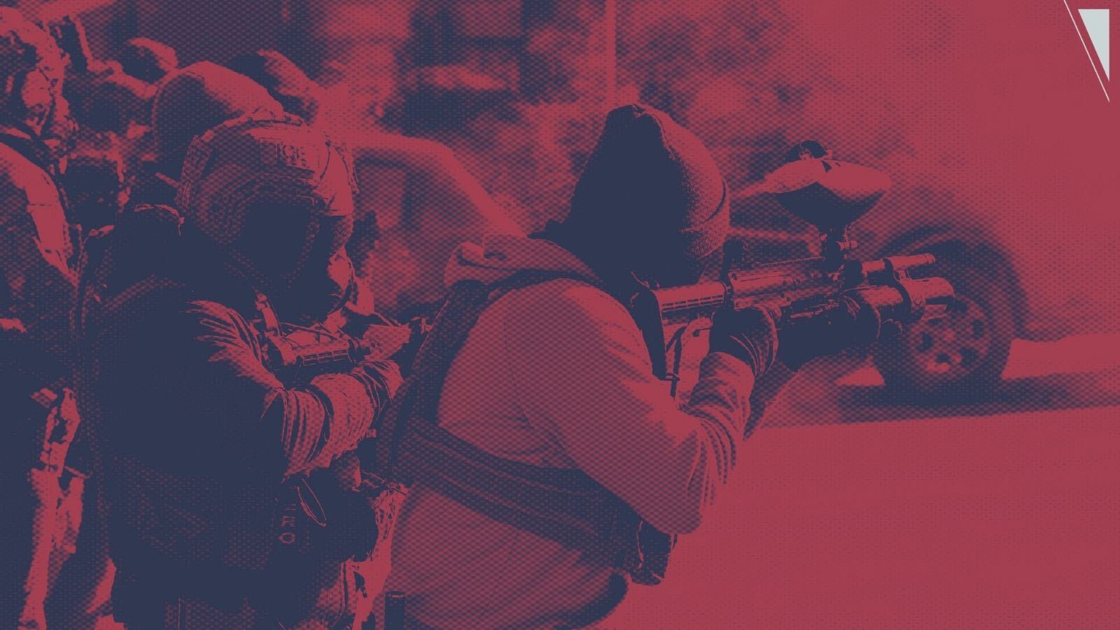 A red-tinted photo of ICE officers shooting non-lethal rounds.