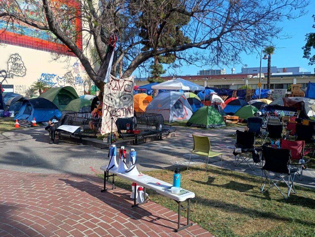 rows of colorful tents and chairs under a banner reading Viva Palestina