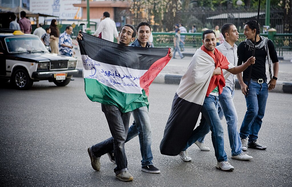 Thousands of Egyptian protesters rallied against religious sectarianism and in solidarity with the Palestinian intifada, in Tahrir Square on Friday May 13th 2011. The photo shows five protestors, one of them marching with Palestinian flag and one with the flag draped over his shoulder. Photo by: Hossam el-Hamalawy حسام الحملاوي.