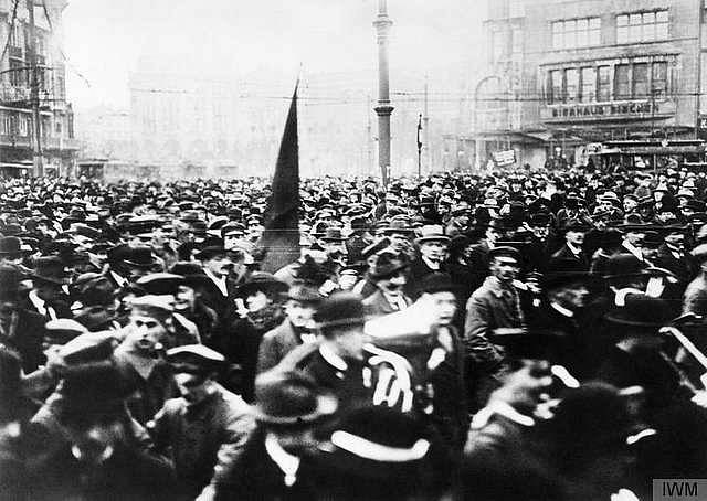 Black-and-white photo of a large crowd packing a city square in the early twentieth century.