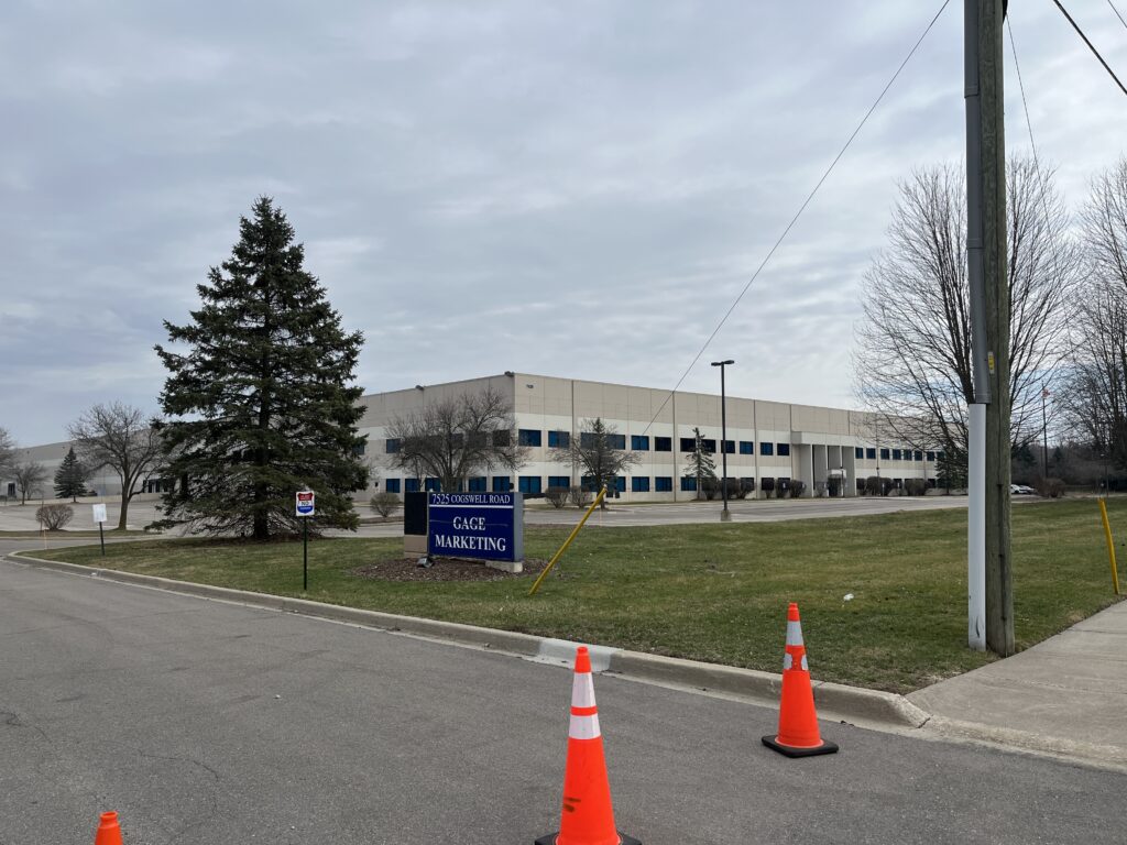 Photo of a building with orange cones in front of it.