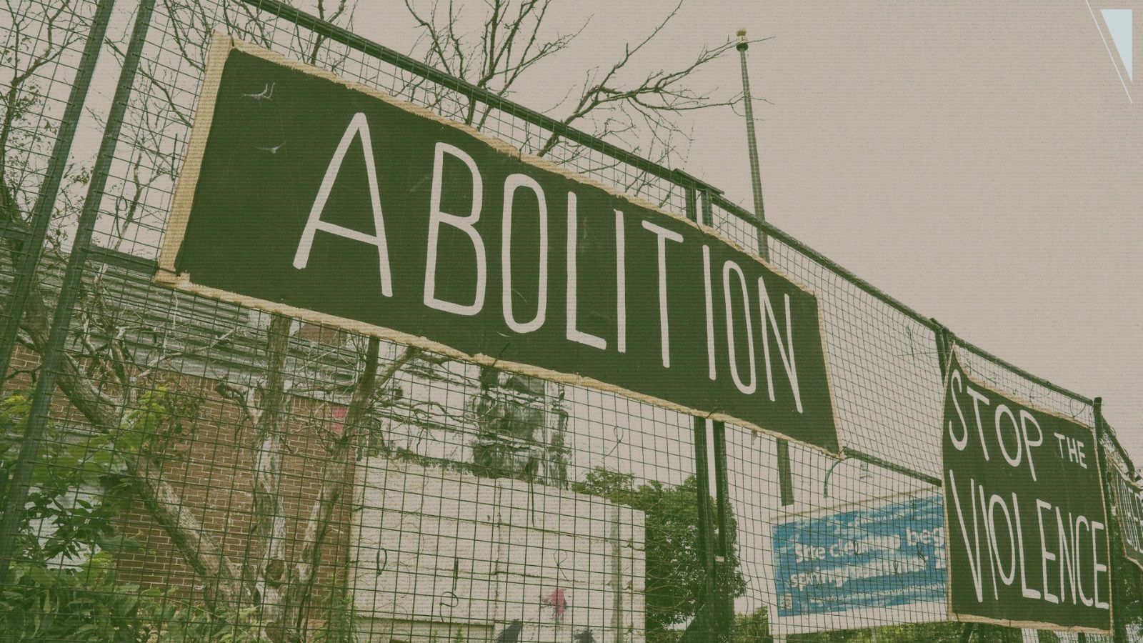 Signs on a fence that say "bolition" and "stop the violence"