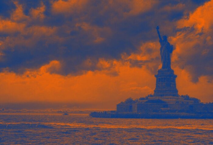 The statue of liberty in shadow on an orange background