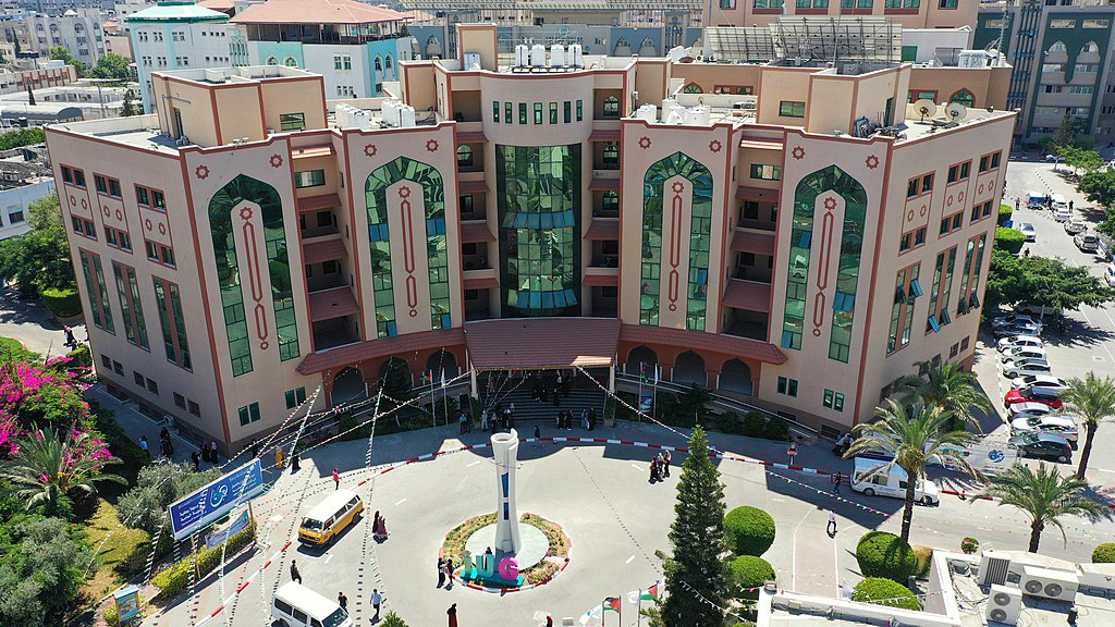 A modern university administration building seen from above and in front. Modular, colorful design with Islamic patterns.