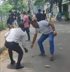 A group of male supporters of the protests shown picking up stones to hurl at police. Photo by Anonymous. Wednesday, July 24