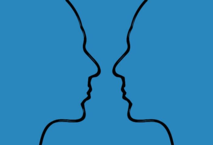 A flat blue background with two outlines of faces facing each other in a side profile.