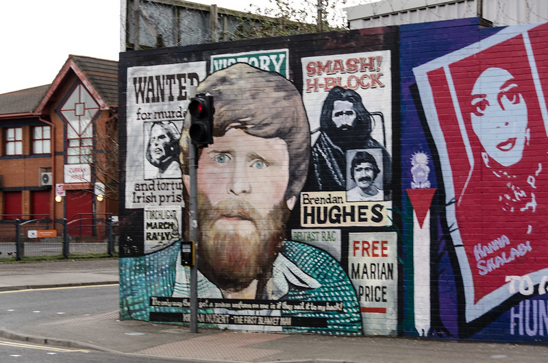 A collage of murals on a wall in Belfast in the North of Ireland, 2013. The murals shows various Irish republican political prisoners as well as a mural of Palestinian political prisoner, Hana Shalabi, who was held in Israeli prison and was on a hunger strike in 2013. Photo by phillip c. reed.