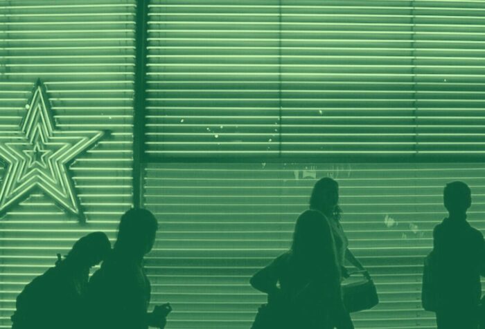 A silhouetted group of students walking, with a green filter over the image.