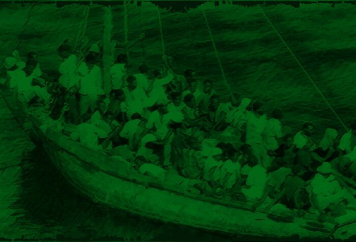 A small boat, packed with people, on the water. Dark green filter overlaying the photo.