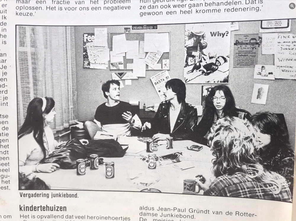 Black and white photo of young adults around a table.