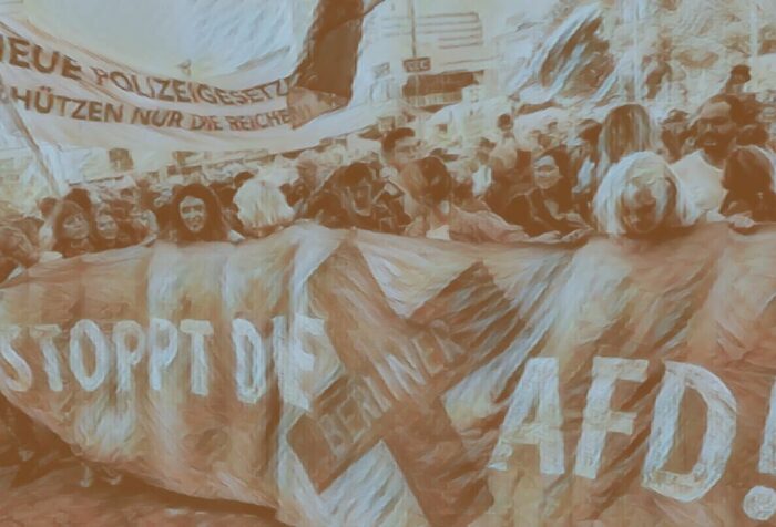 A crowd of people hold a long banner saying "Stoppt Die Afd!"