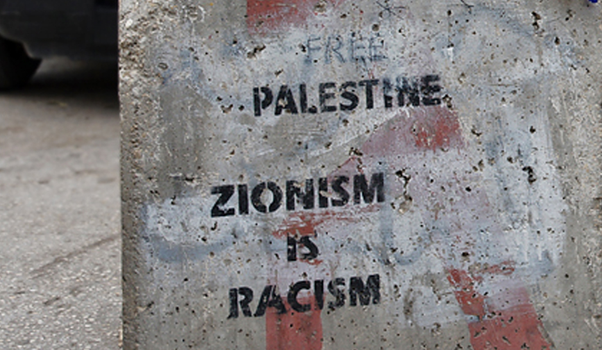 Concrete block with stenciled message: “Free Palestine. Zionism is racism.”