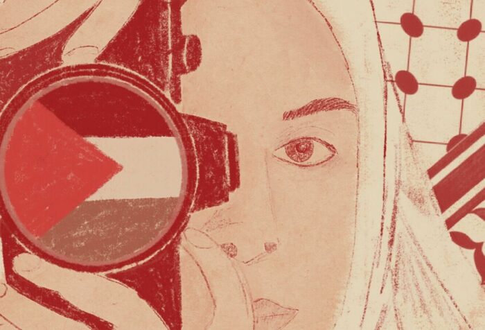 A drawing. Background: a keffiyeh pattern. Foreground: A woman in a white hijab holds a camera up to her face. A Palestinian flag is in the lens.
