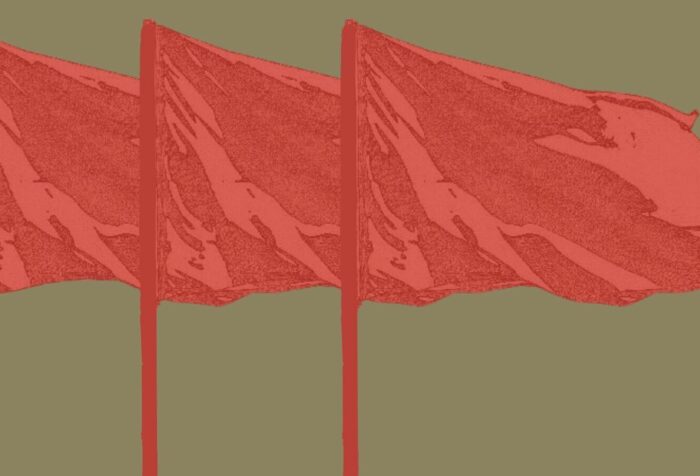 A dark brown-green background. Against it are three red flags waving.
