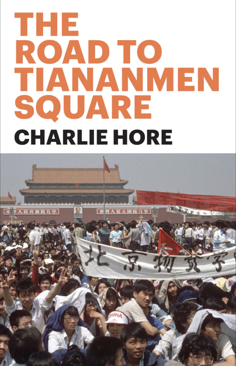 An image of a book cover. The top half has a white backround with orange text reading "The Road to Tianenmen Square" above black text reading "Charlie Hore." The bottom half is an image of a crowd holding banners in Chinese.