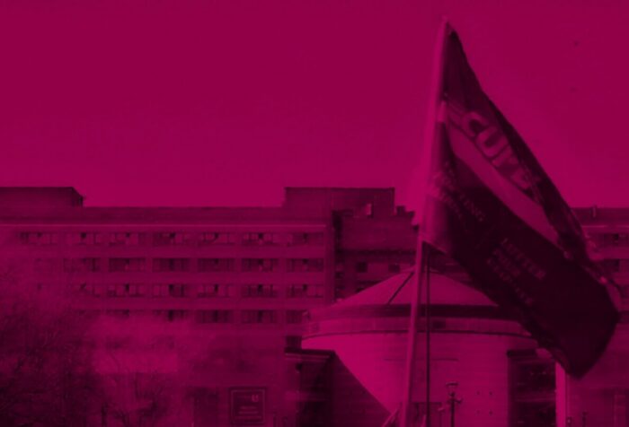A fuschia-filtered photo of a CUPE flag flying in front of a building.