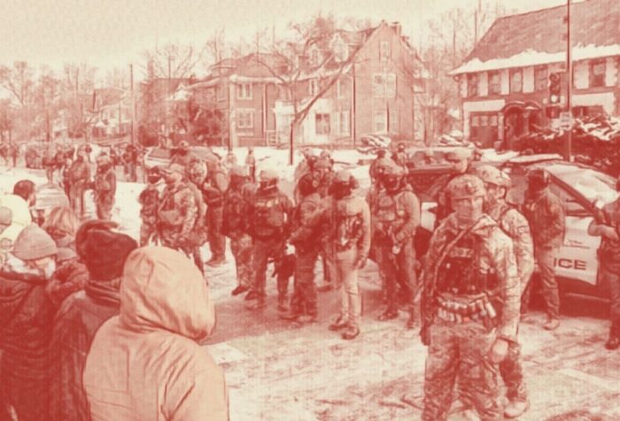 On a street of houses, a row of police and police cars faces a group of people. The photo is filtered with a cream and brown color filter.