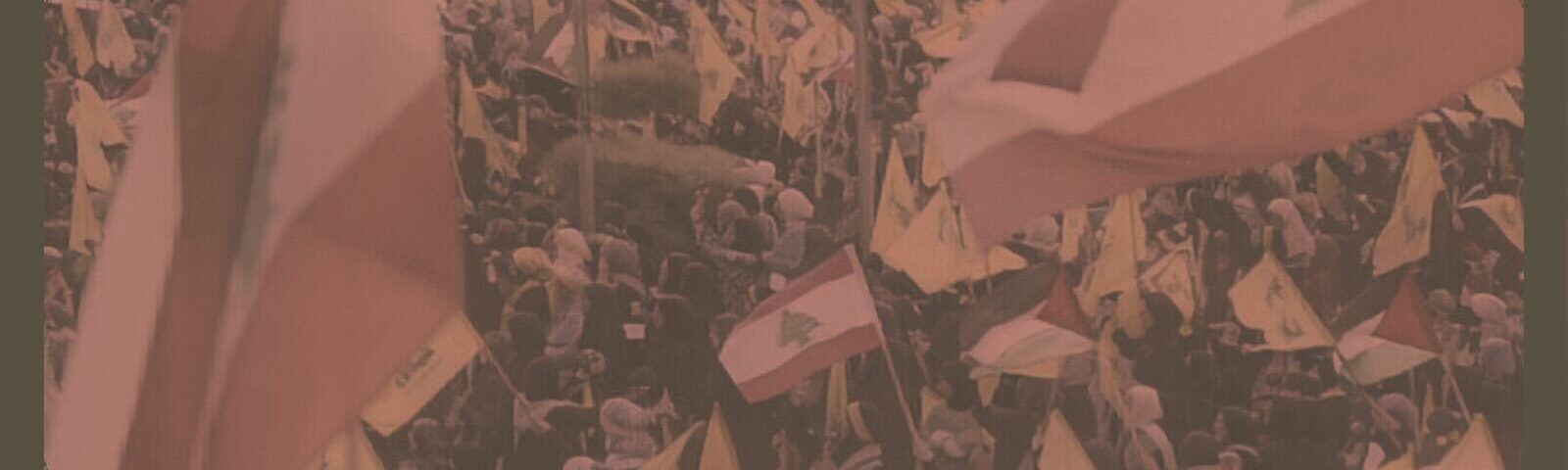 A crowd waves flags of Lebanon and Hezbollah.