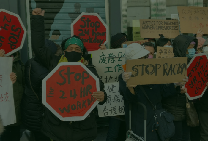 A group of people protesting holding signs in English and Chinese.