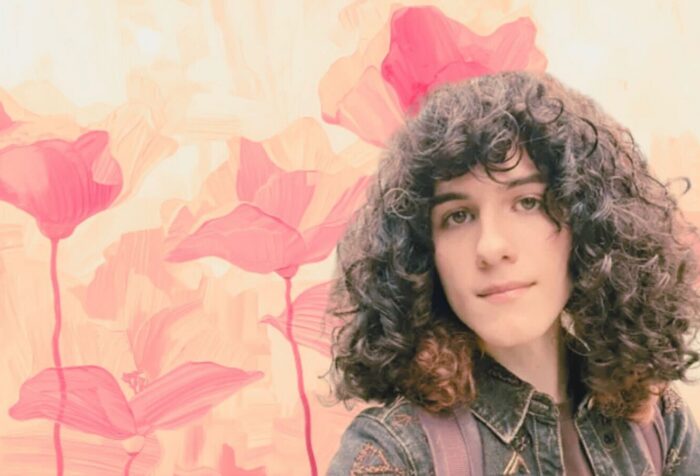 A photo of Juniper Blessing, edited in front of pink flowers.
