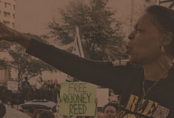 Sandra Reed points and speaks over a crowd.