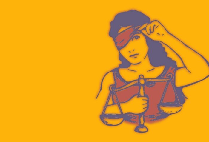 Lady justice holds the scales and lifts her blindfold.