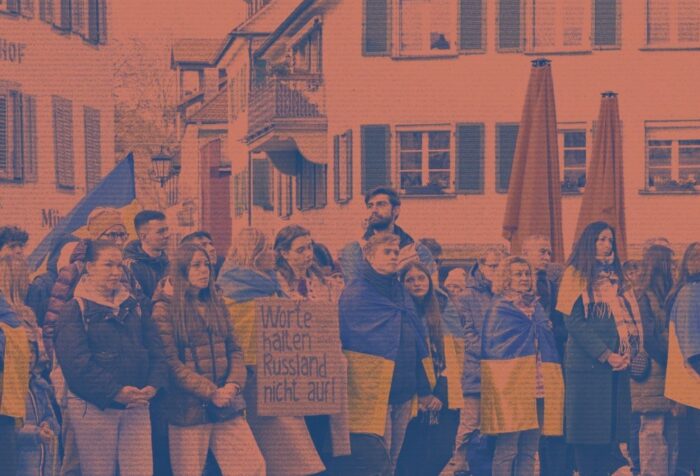 A crowd of people holding Ukranian flags.